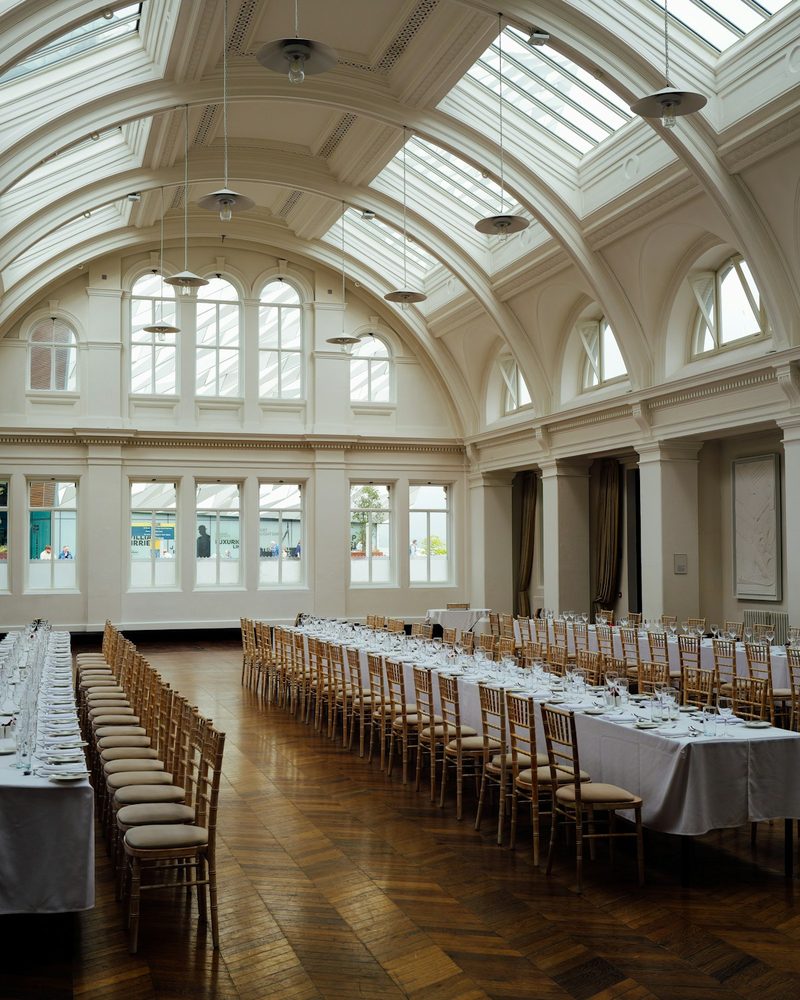 Grand event hall with soaring arched skylight ceiling and long banquet tables
