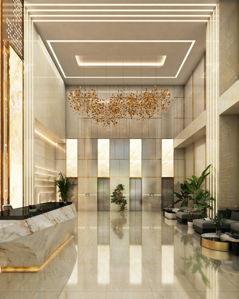 Ultra-luxury hotel lobby with marble reception desk and cascading gold chandelier