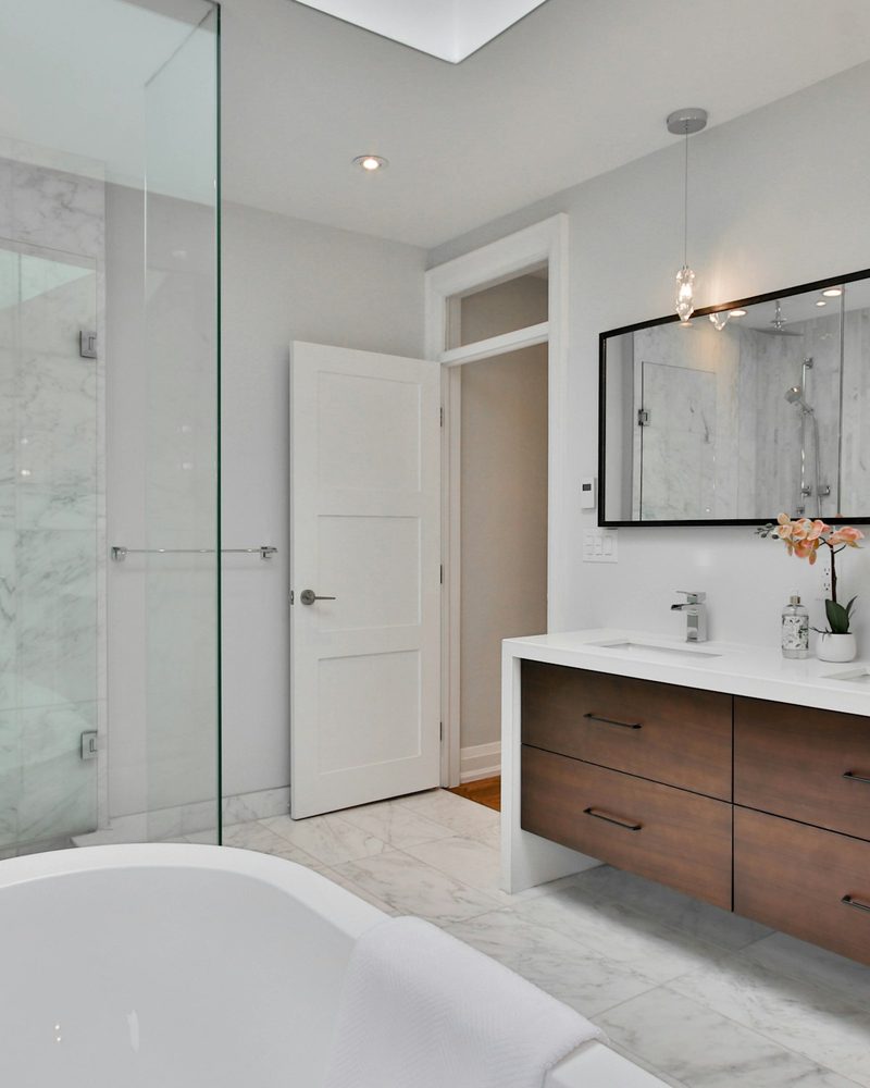 Marble-clad master washroom with brushed brass fixtures