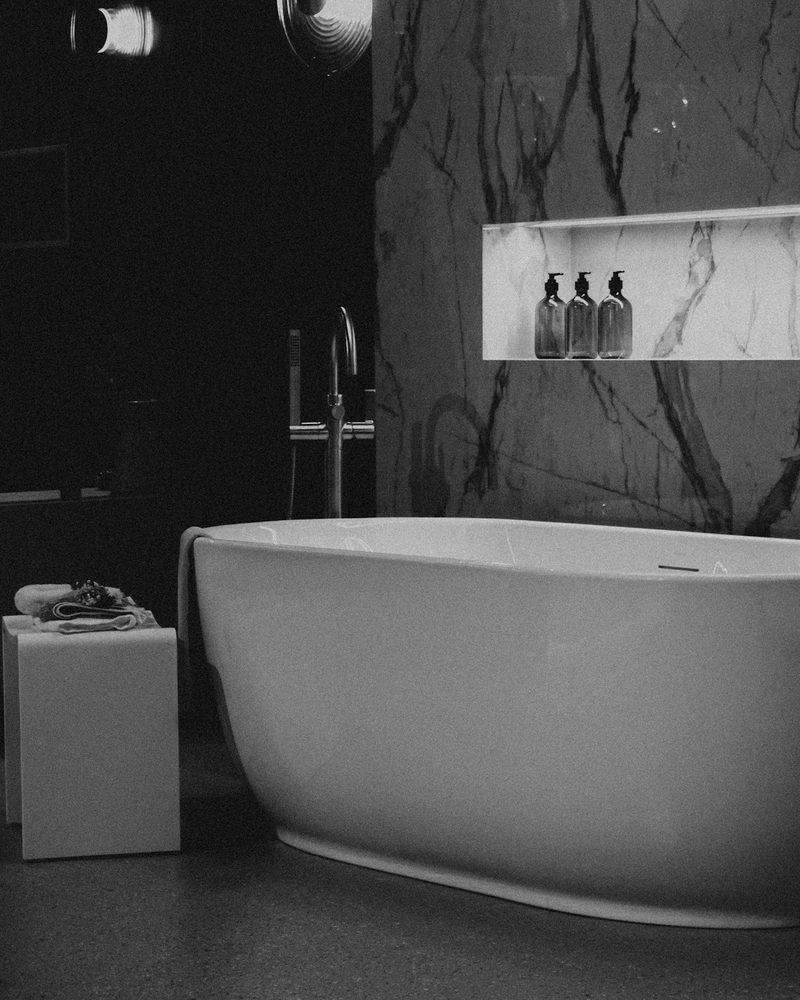 Dramatic marble feature wall as the focal point behind a freestanding tub