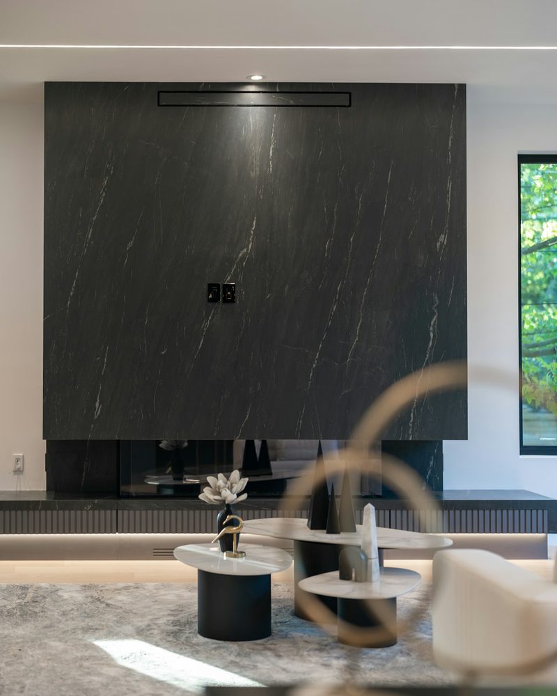 Book-matched black marble feature wall as the focal point of a modern luxury living room